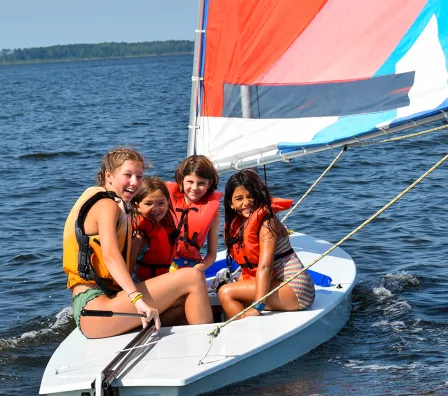 Three campers and a counselor on a sailboat