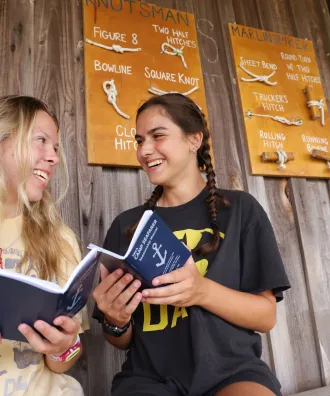 Two girls reviewing the blue books