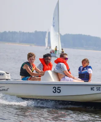 Four boys on a motorboat