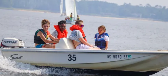Four boys on a motorboat