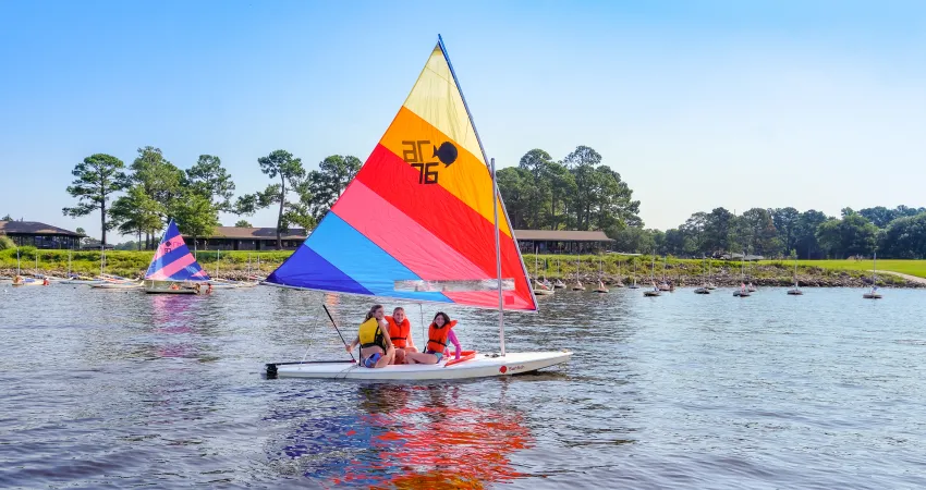 Three girls on a sailboat at Camp Seafarer